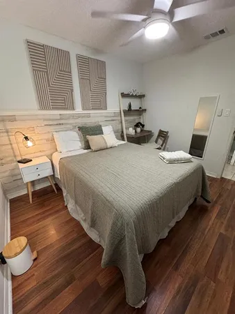 a bedroom with bed and wooden floor