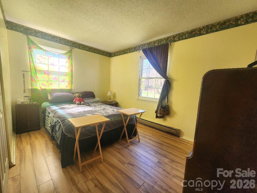 203 Brentwood Road, Unit 61 Morganton, NC 28655 - Photo 7 of 11 a spacious bedroom with a bed and wooden floor