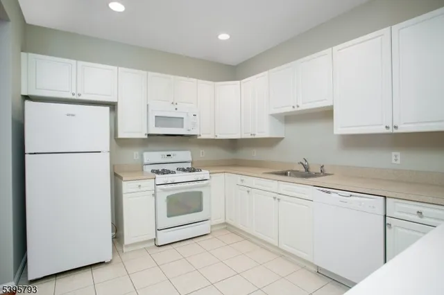 a kitchen with cabinets stainless steel appliances and a sink