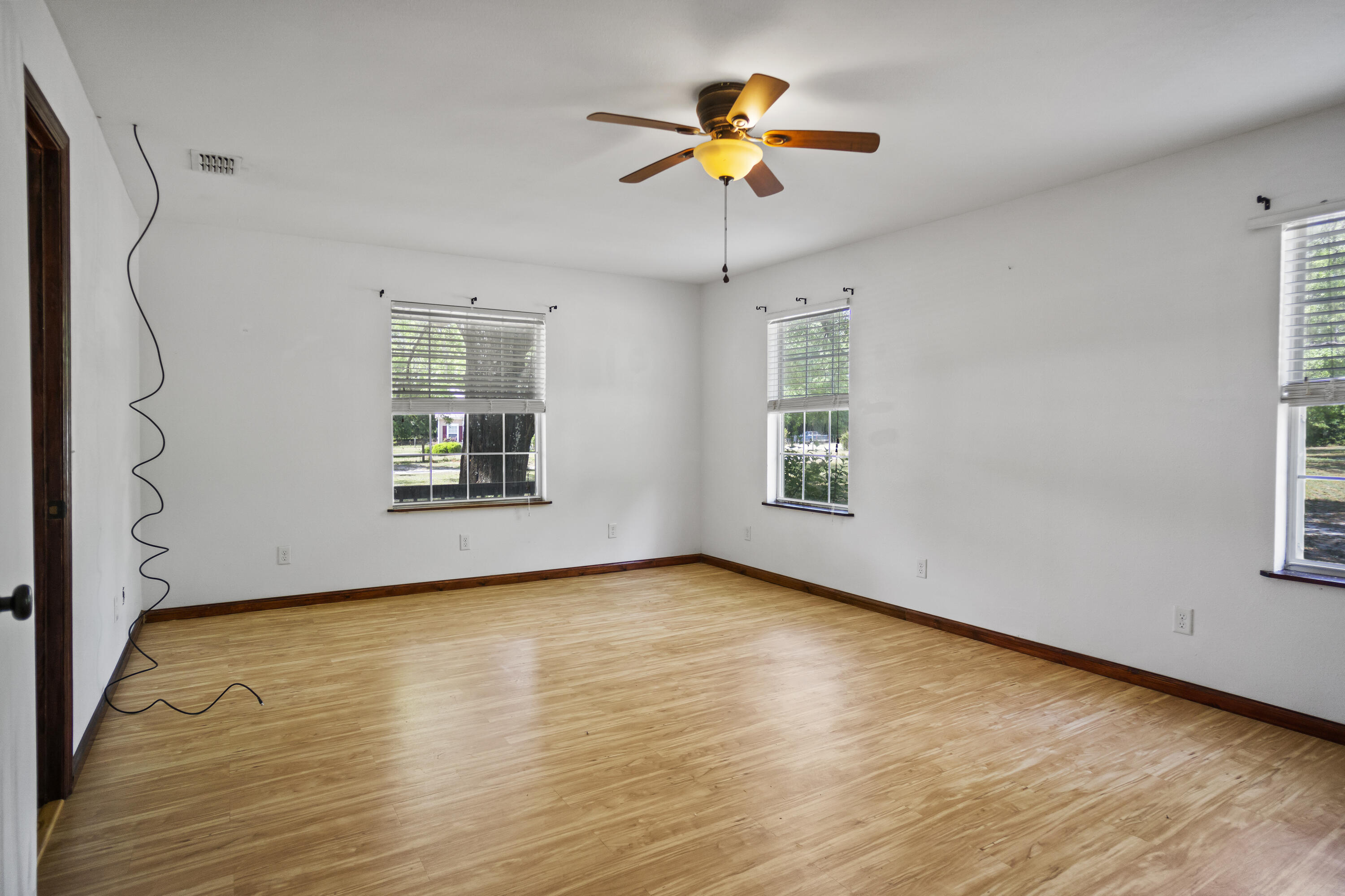 15766 Northeast Bob Sanders Road Hosford, FL 32334 - Photo 5 of 33 a view of an empty room with a window and wooden floor