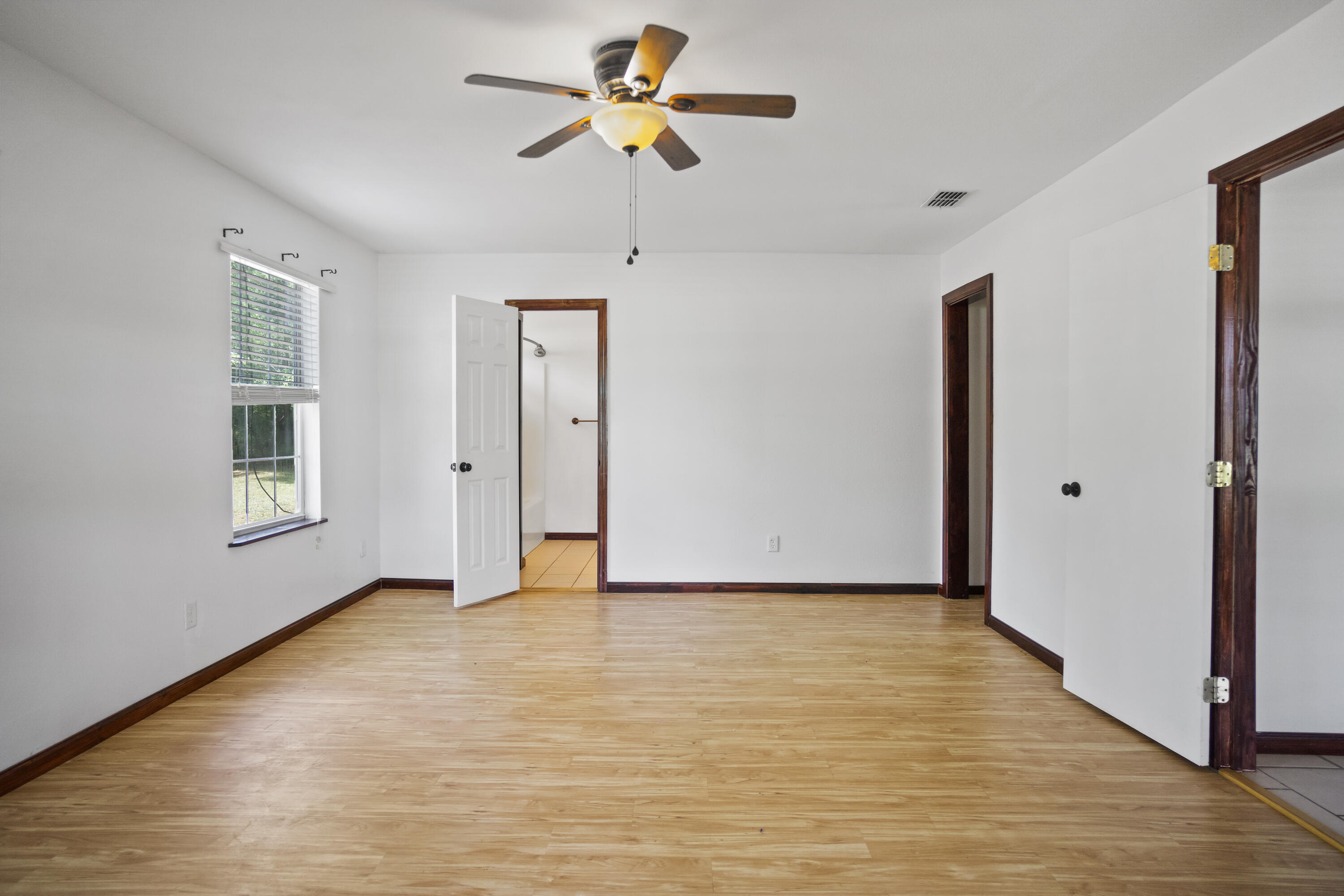 15766 Northeast Bob Sanders Road Hosford, FL 32334 - Photo 6 of 33 a view of empty room with wooden floor and fan
