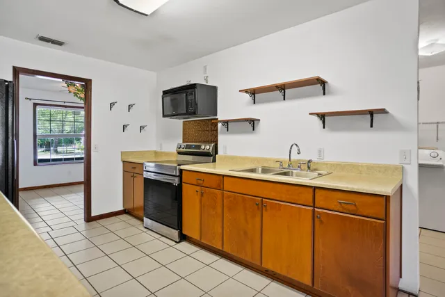 a kitchen with stainless steel appliances granite countertop a sink and a stove top oven