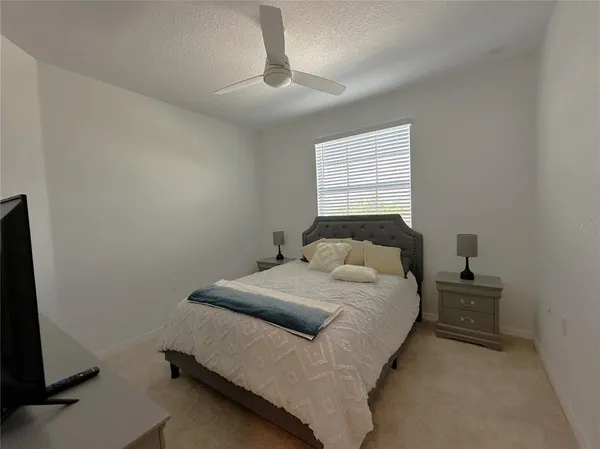 a bedroom with a bed and a ceiling fan