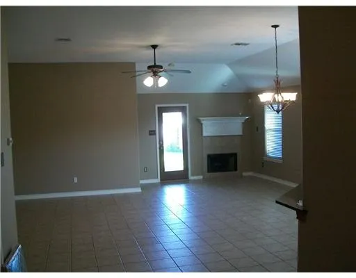 a view of empty room with wooden floor and fireplace