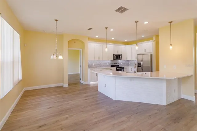 a large kitchen with a lot of counter space and a wooden floor