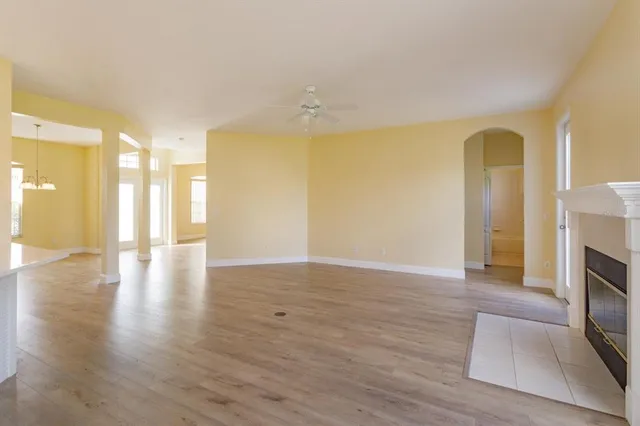 a view of empty room with wooden floor and fireplace