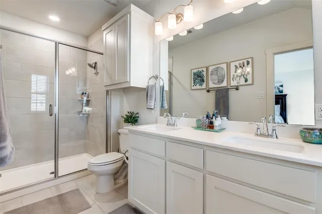 a bathroom with a double vanity sink toilet and shower