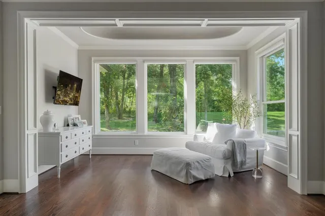 a spacious bedroom with a bed and a flat tv screen on a dresser