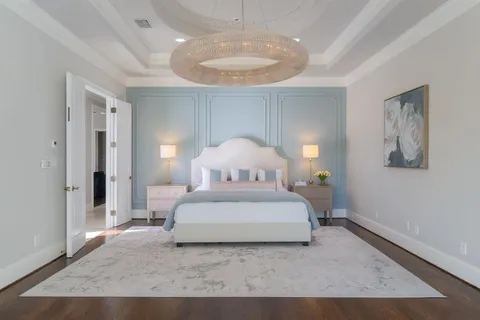 a spacious bedroom with a bed and a chandelier