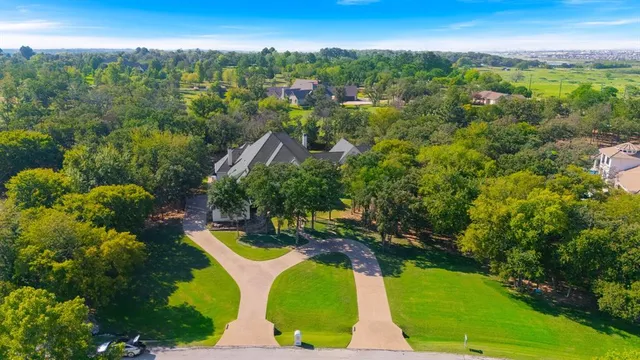 an aerial view of residential houses with outdoor space and trees