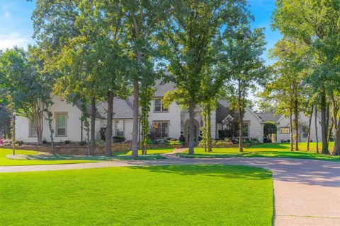 a view of a house with palm trees and a tree
