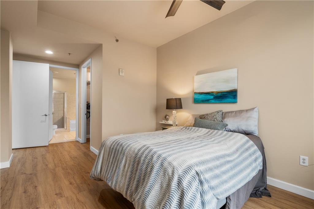 711 Cosmopolitan Drive Northeast, Unit 517 Atlanta, GA 30324 - Photo 12 of 29 a bedroom with a bed and a painting on the wall