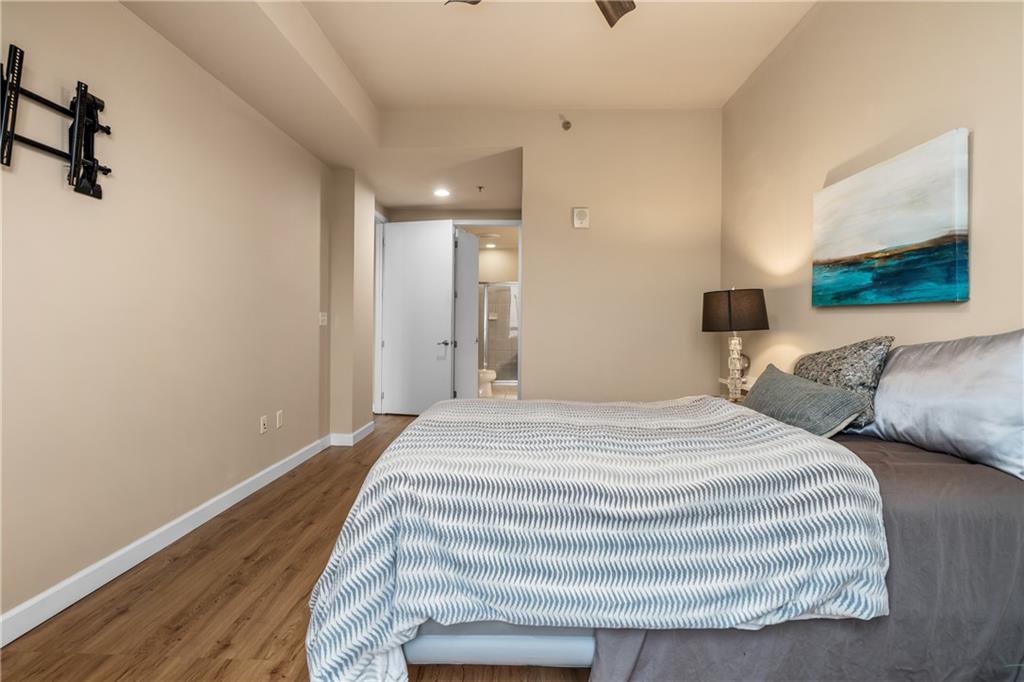711 Cosmopolitan Drive Northeast, Unit 517 Atlanta, GA 30324 - Photo 13 of 29 a bedroom with a bed and a painting on the wall