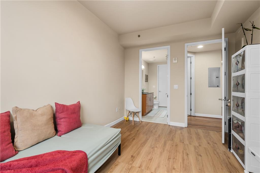 711 Cosmopolitan Drive Northeast, Unit 517 Atlanta, GA 30324 - Photo 18 of 29 a bedroom with a bed and a wooden floor