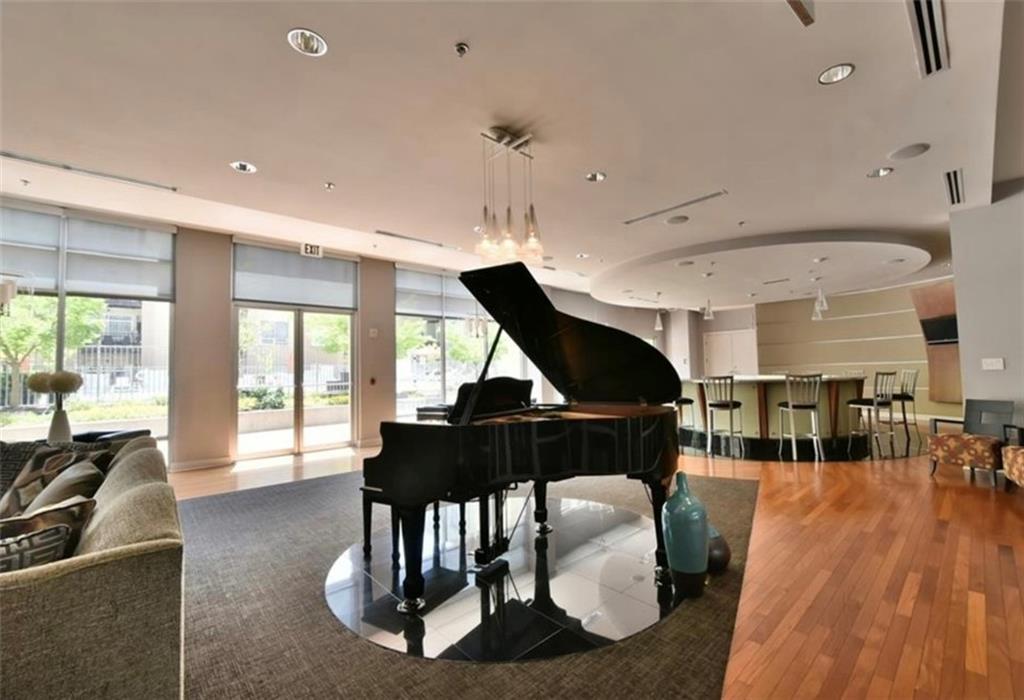 711 Cosmopolitan Drive Northeast, Unit 517 Atlanta, GA 30324 - Photo 24 of 29 a living room with furniture a wooden floor and a chandelier