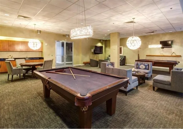 a living room with furniture a flat screen tv and kitchen view