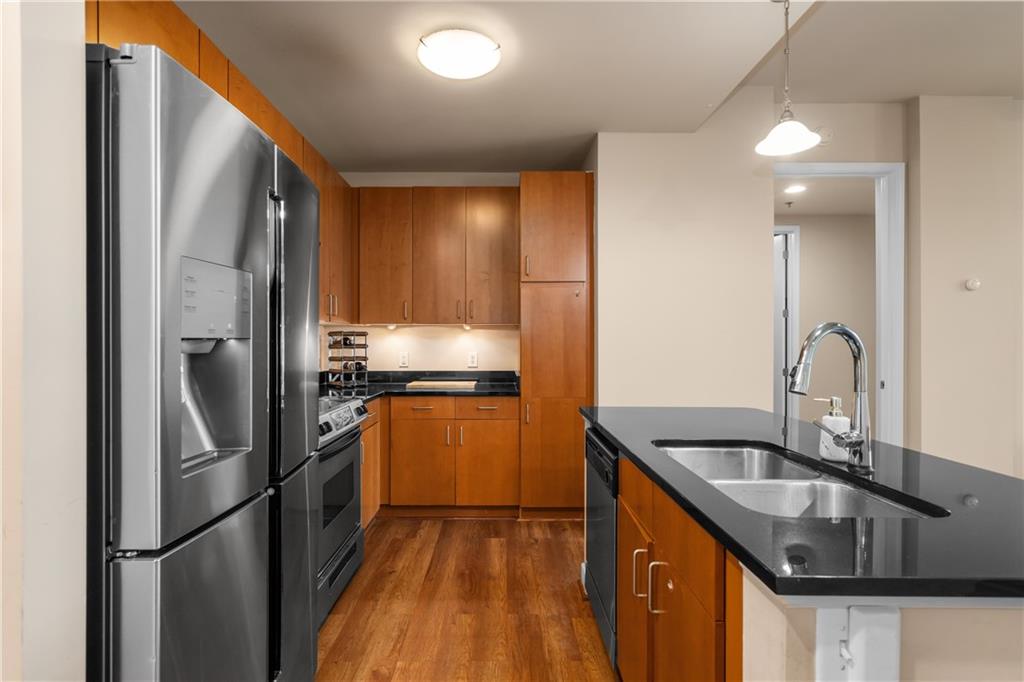 711 Cosmopolitan Drive Northeast, Unit 517 Atlanta, GA 30324 - Photo 3 of 29 a kitchen with stainless steel appliances granite countertop a refrigerator a sink and a stove