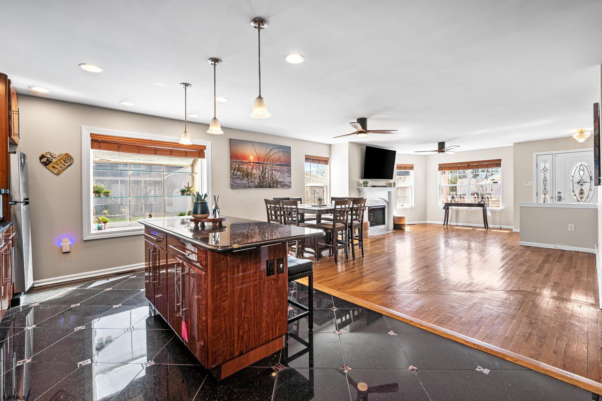 5 Collette Circle Brigantine, NJ 08203 - Photo 11 of 36 a view of a dining room and livingroom with furniture wooden floor a rug a flat screen tv and a large window