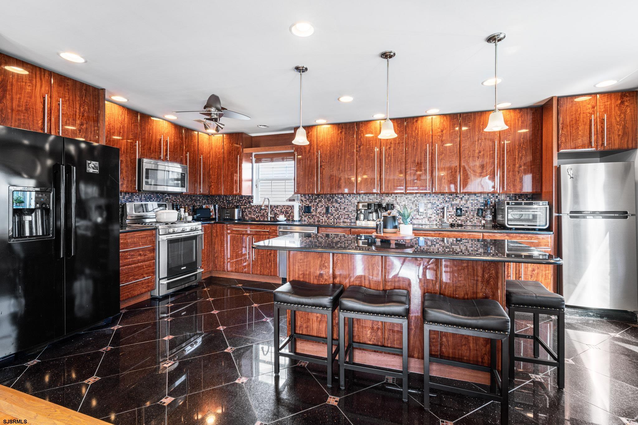 5 Collette Circle Brigantine, NJ 08203 - Photo 10 of 36 a kitchen with stainless steel appliances granite countertop a refrigerator a stove and a sink with wooden floor