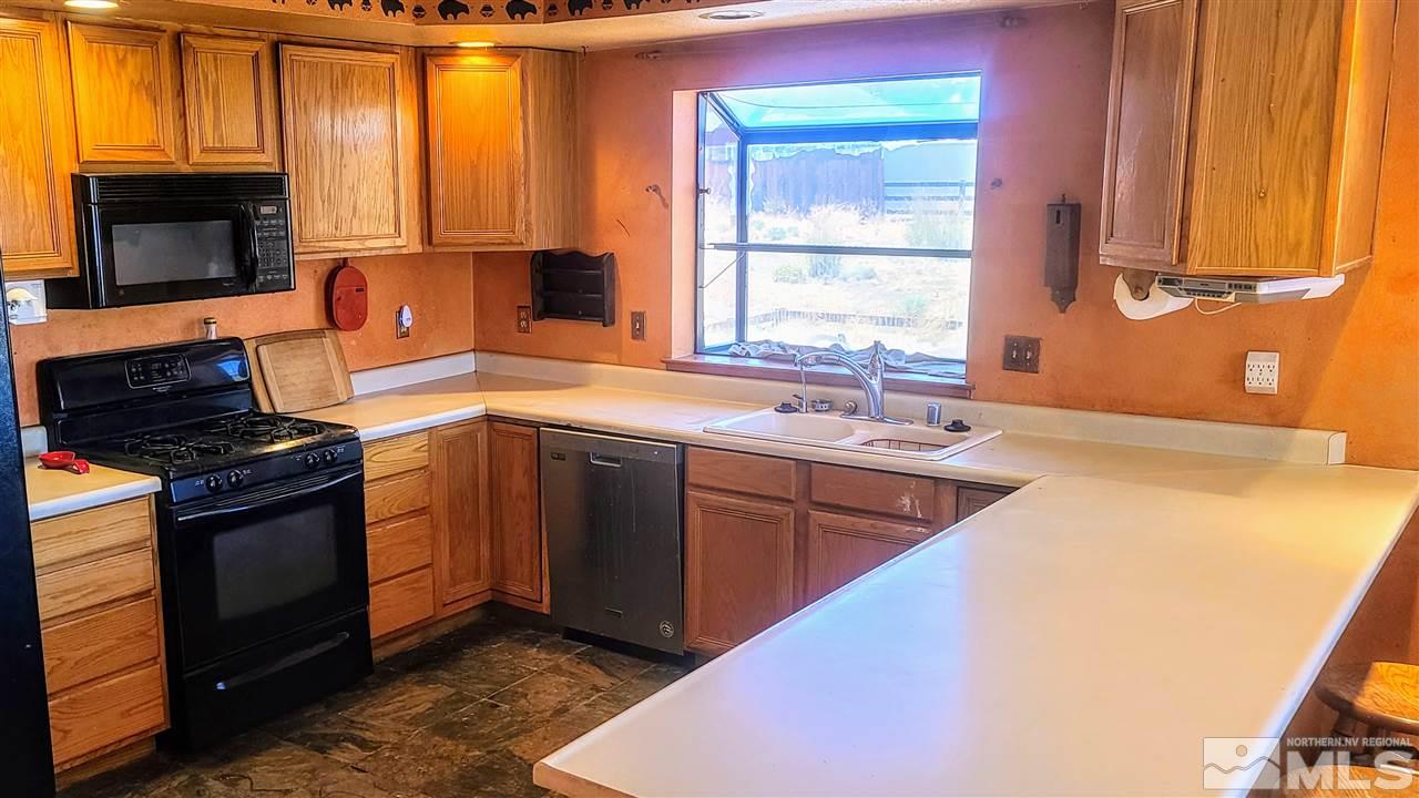 2440 Lousetown Road Reno, NV 89521 - Photo 4 of 20 a kitchen with stainless steel appliances granite countertop a sink stove and microwave