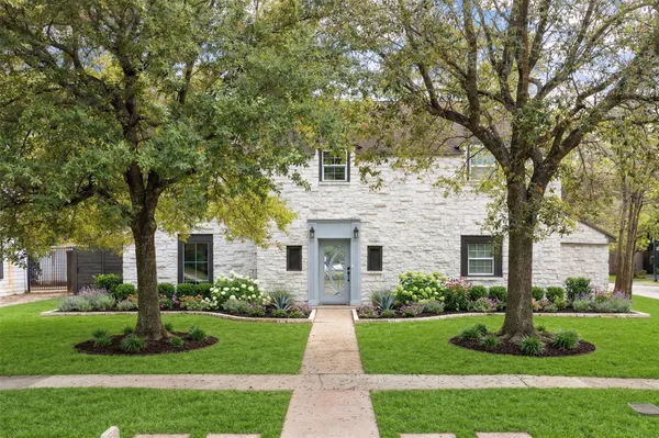 a front view of a house with a yard and an trees
