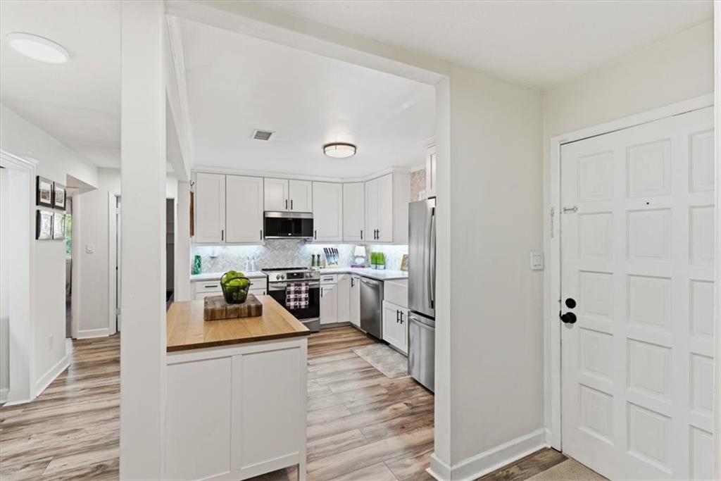 2907 Ironwood Road Southeast Marietta, GA 30067 - Photo 7 of 41 a kitchen with white cabinets and stainless steel appliances