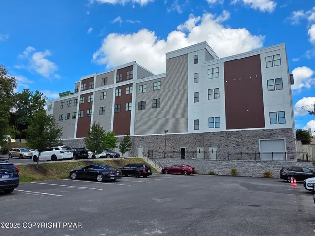 a view of building with cars parked in front of it