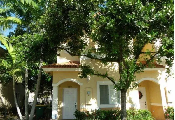 a view of a brick house next to a large tree