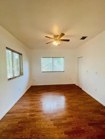 a view of an empty room with window and a ceiling fan