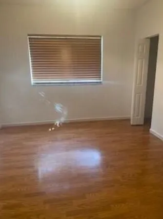 a view of a room with wooden floor and a window