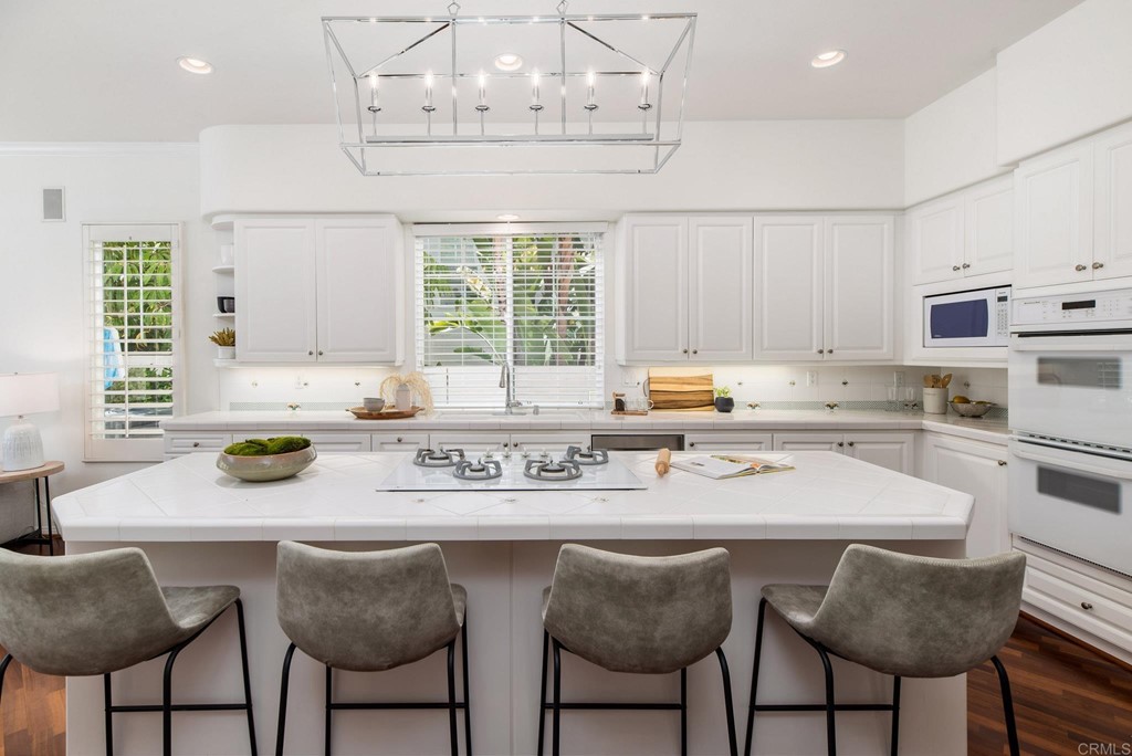 1368 Corvidae Street Carlsbad, CA 92011 - Photo 8 of 38 a kitchen with stainless steel appliances granite countertop a sink and a white cabinets