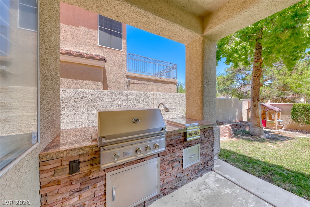 2122 Mooreview Street Henderson, NV 89012 - Photo 35 of 44 An outdoor kitchen with a built-in barbecue and sink offers alfresco dining and entertaining.