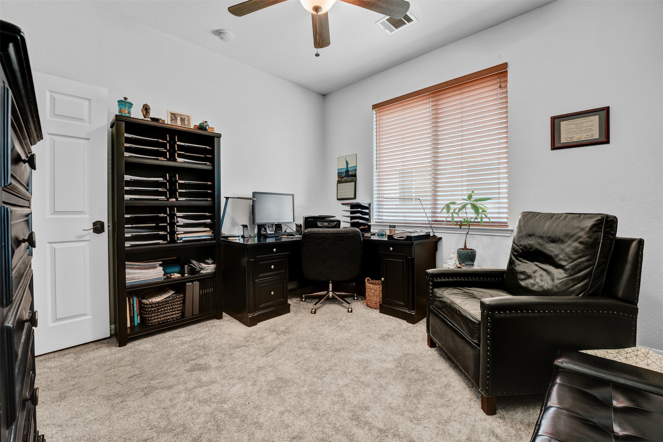 2521 Amen Corner Road Pflugerville, TX 78660 - Photo 25 of 40 Carpeted room featuring a white paneled door, a window with wood-finish blinds, and a ceiling fan with integrated lighting