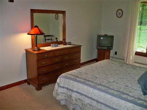 284 Mountain Road Gill, MA 01354 - Photo 16 of 28 a bedroom with a bed and a flat screen tv