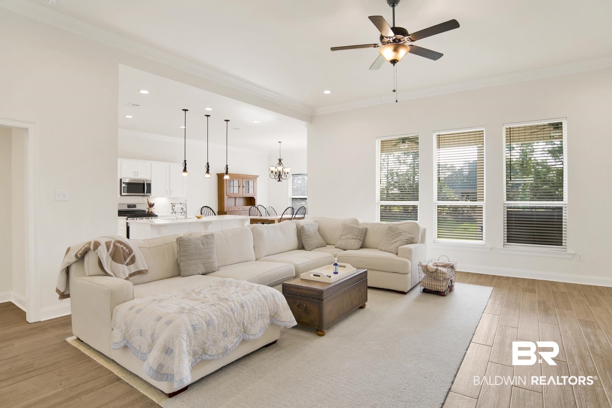 22258 Hibiscus Circle Foley, AL 36535 - Photo 12 of 26 Living area with baseboards, light wood-style floors, crown molding, and ceiling fan with notable chandelier