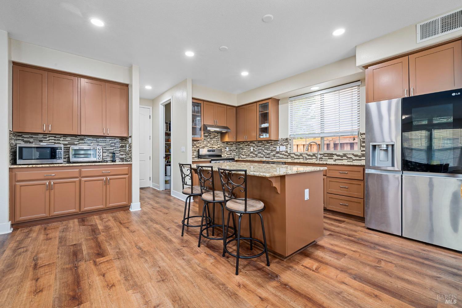 1461-1463 Trombetta Street Santa Rosa, CA 95407 - Photo 19 of 53 a kitchen with stainless steel appliances granite countertop a stove a sink dishwasher a refrigerator and white cabinets with wooden floor