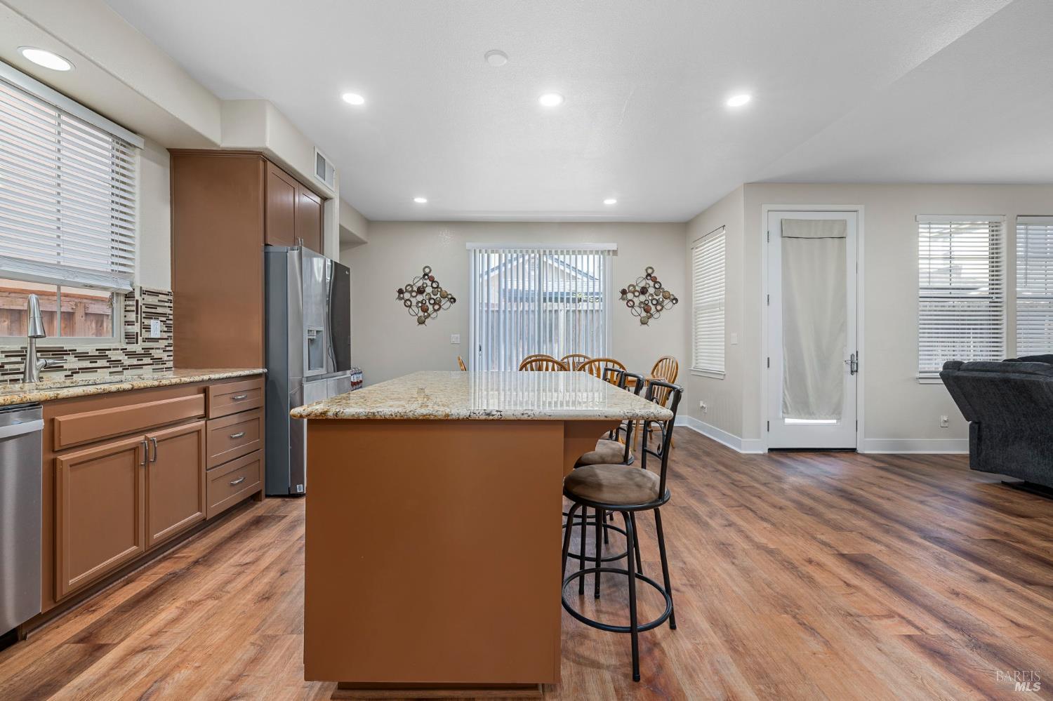 1461-1463 Trombetta Street Santa Rosa, CA 95407 - Photo 23 of 53 a kitchen with stainless steel appliances granite countertop a table chairs sink refrigerator and cabinets