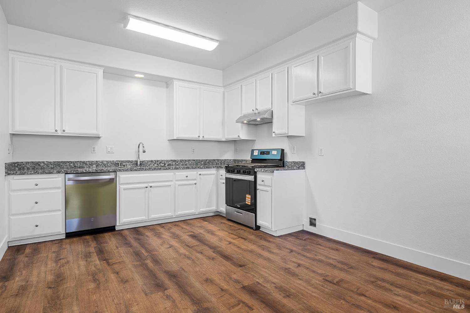 1461-1463 Trombetta Street Santa Rosa, CA 95407 - Photo 35 of 53 a kitchen with granite countertop white cabinets and white appliances