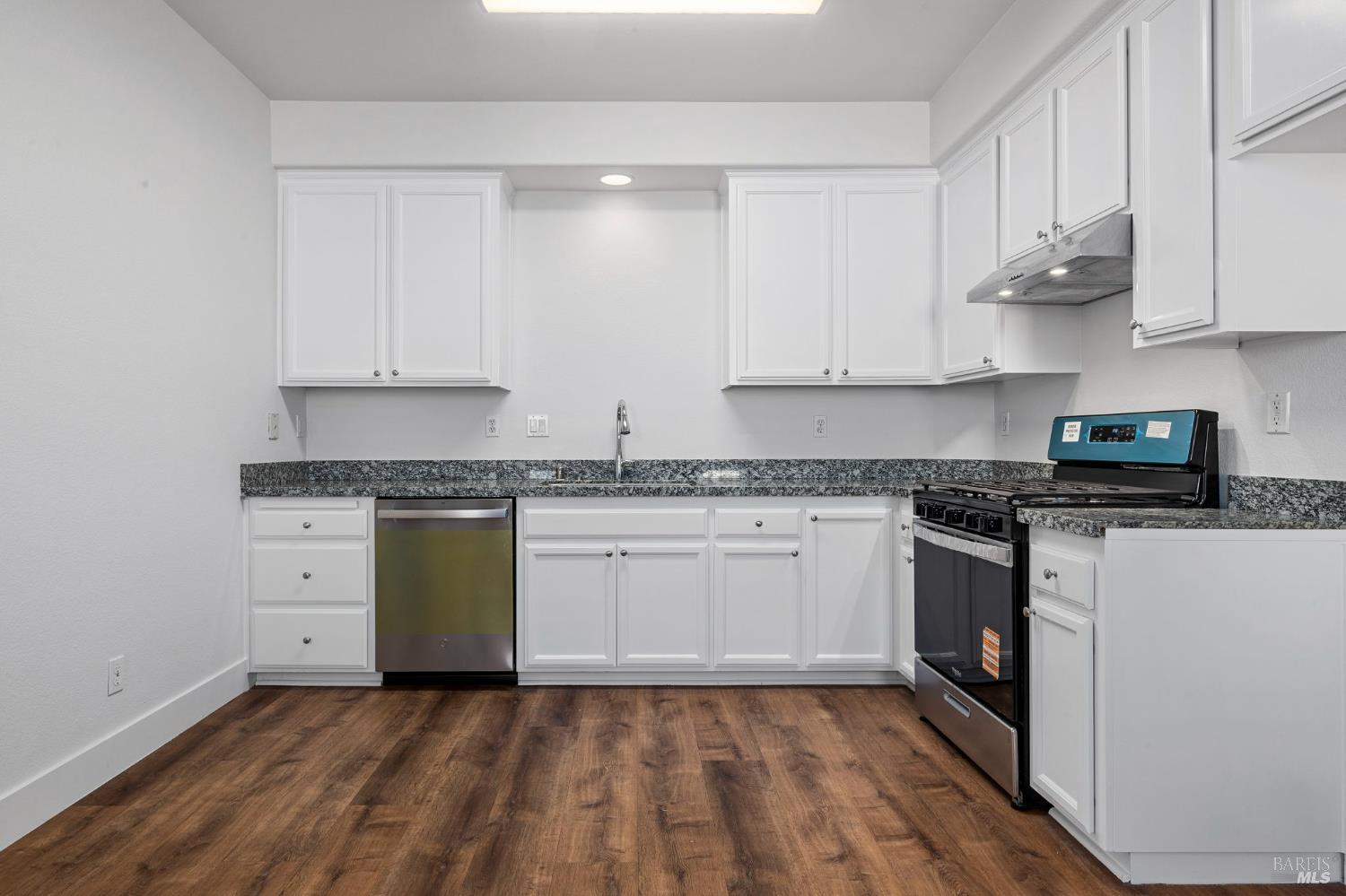 1461-1463 Trombetta Street Santa Rosa, CA 95407 - Photo 38 of 53 a kitchen with granite countertop white cabinets and white appliances