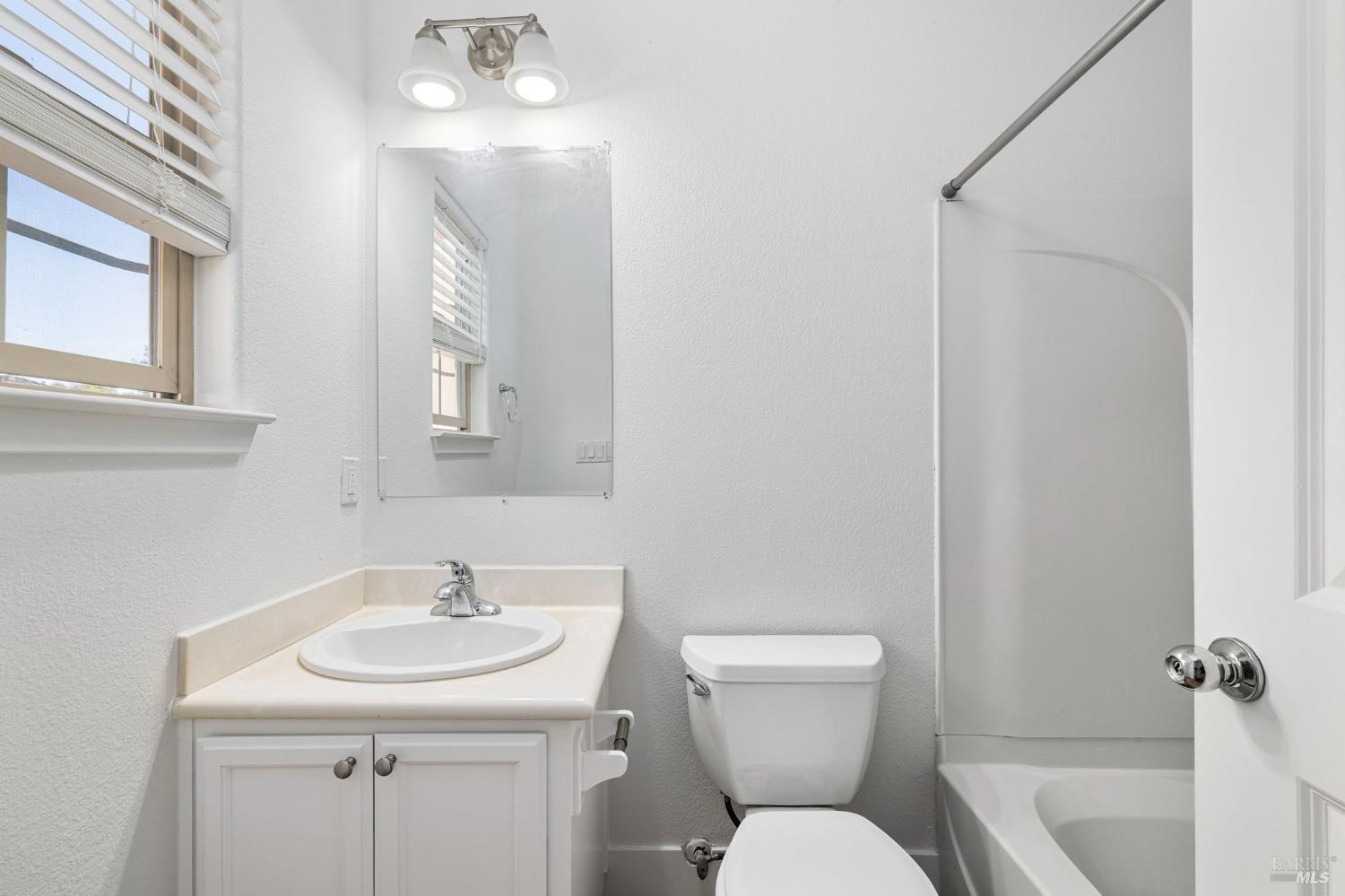 1461-1463 Trombetta Street Santa Rosa, CA 95407 - Photo 41 of 53 a bathroom with a toilet sink and mirror