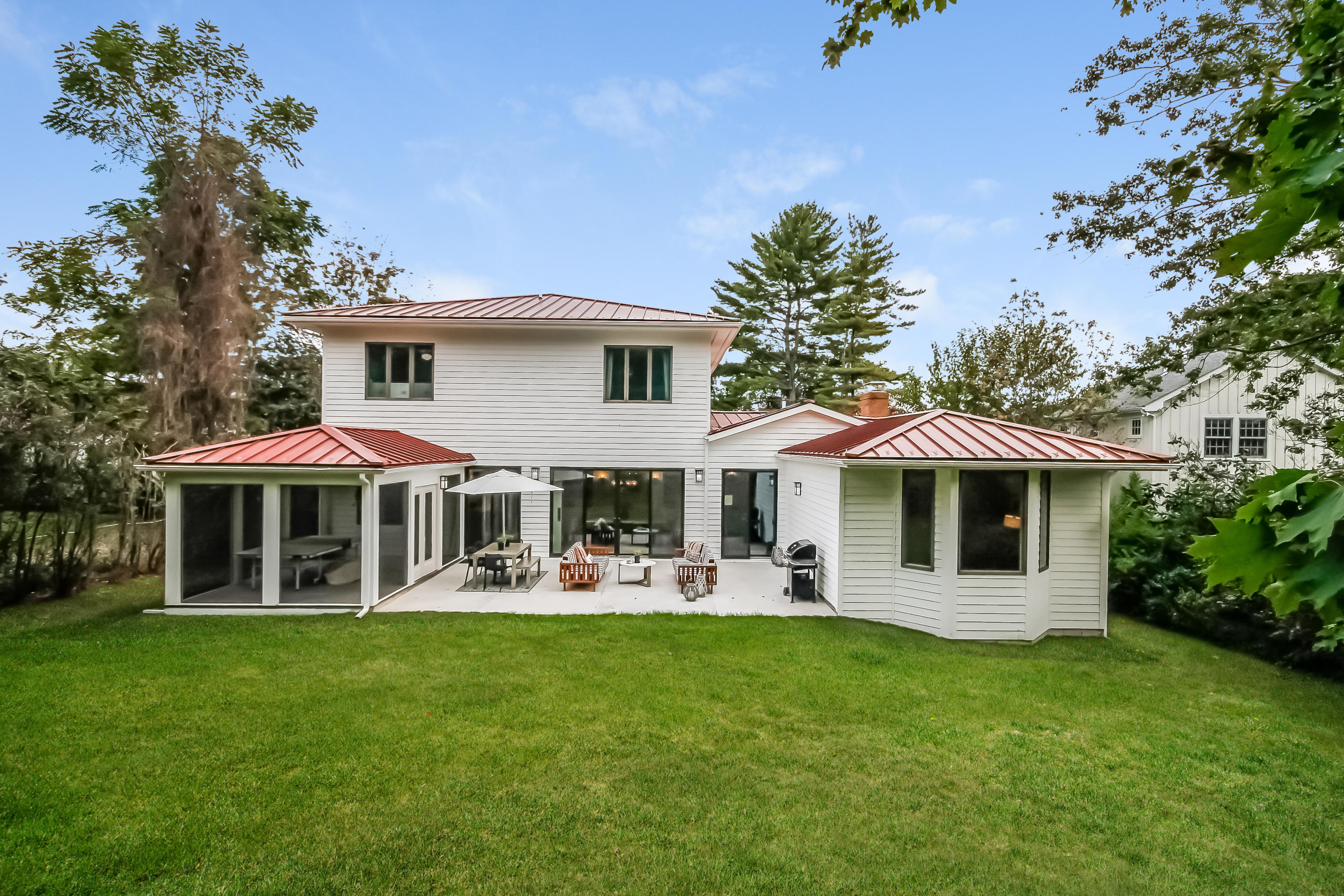 15 Marshall Ridge Road New Canaan, CT 06840 - Photo 28 of 30 a front view of a house with a yard table and chairs