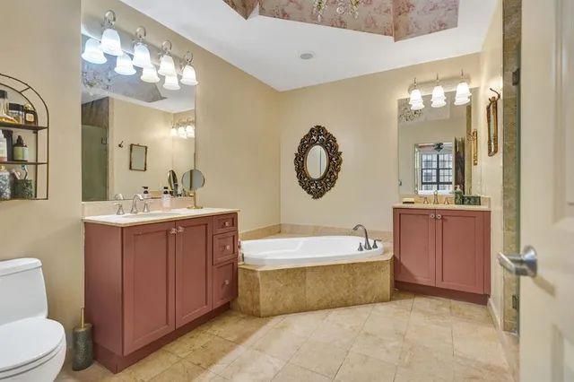 a spacious bathroom with a double vanity sink mirror and bathtub
