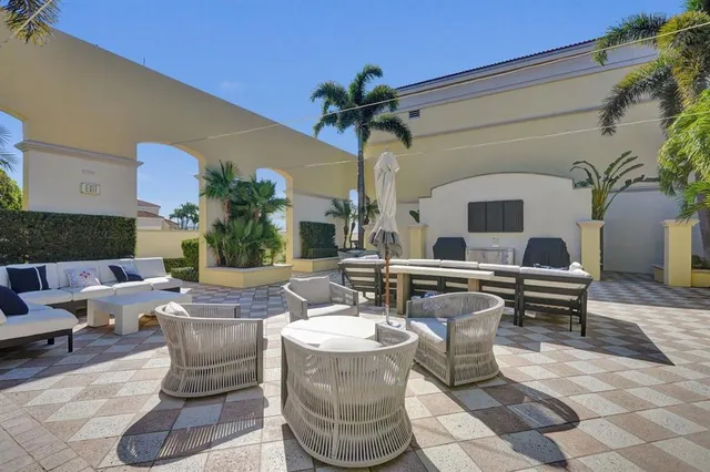 a living room with couches a fireplace and a potted plant