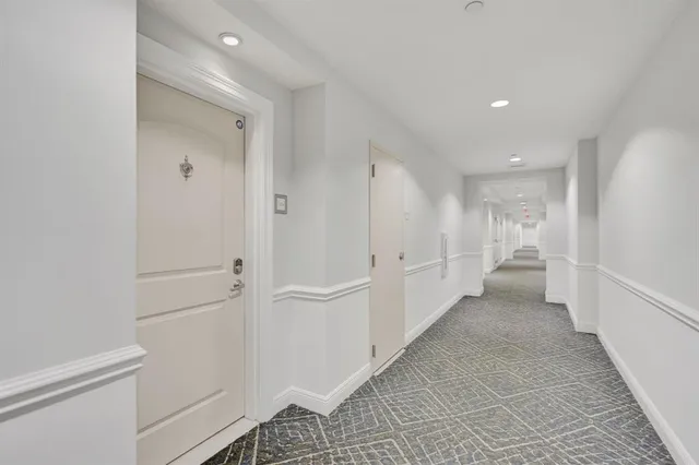 a view of a hallway with white walls and stairs