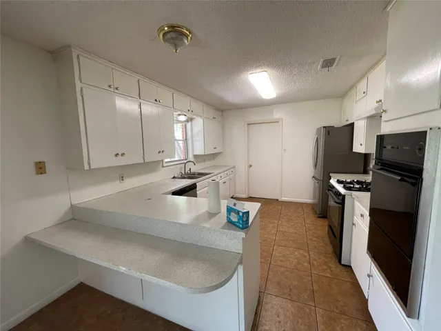 a kitchen with stainless steel appliances a sink a stove and a refrigerator