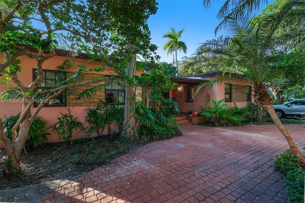 a view of a house with a tree in front of it