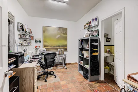 a view of a workspace with furniture and a bookshelf