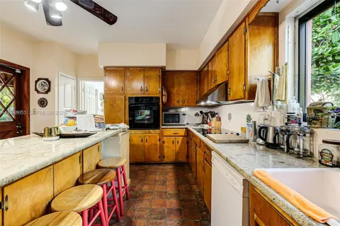 a kitchen with stainless steel appliances granite countertop lots of counter top space and wooden floor