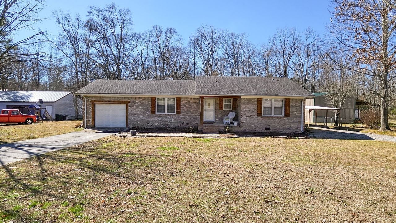 a front view of a house with a yard and trees