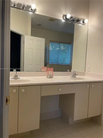 a bathroom with a double vanity sink and a mirror